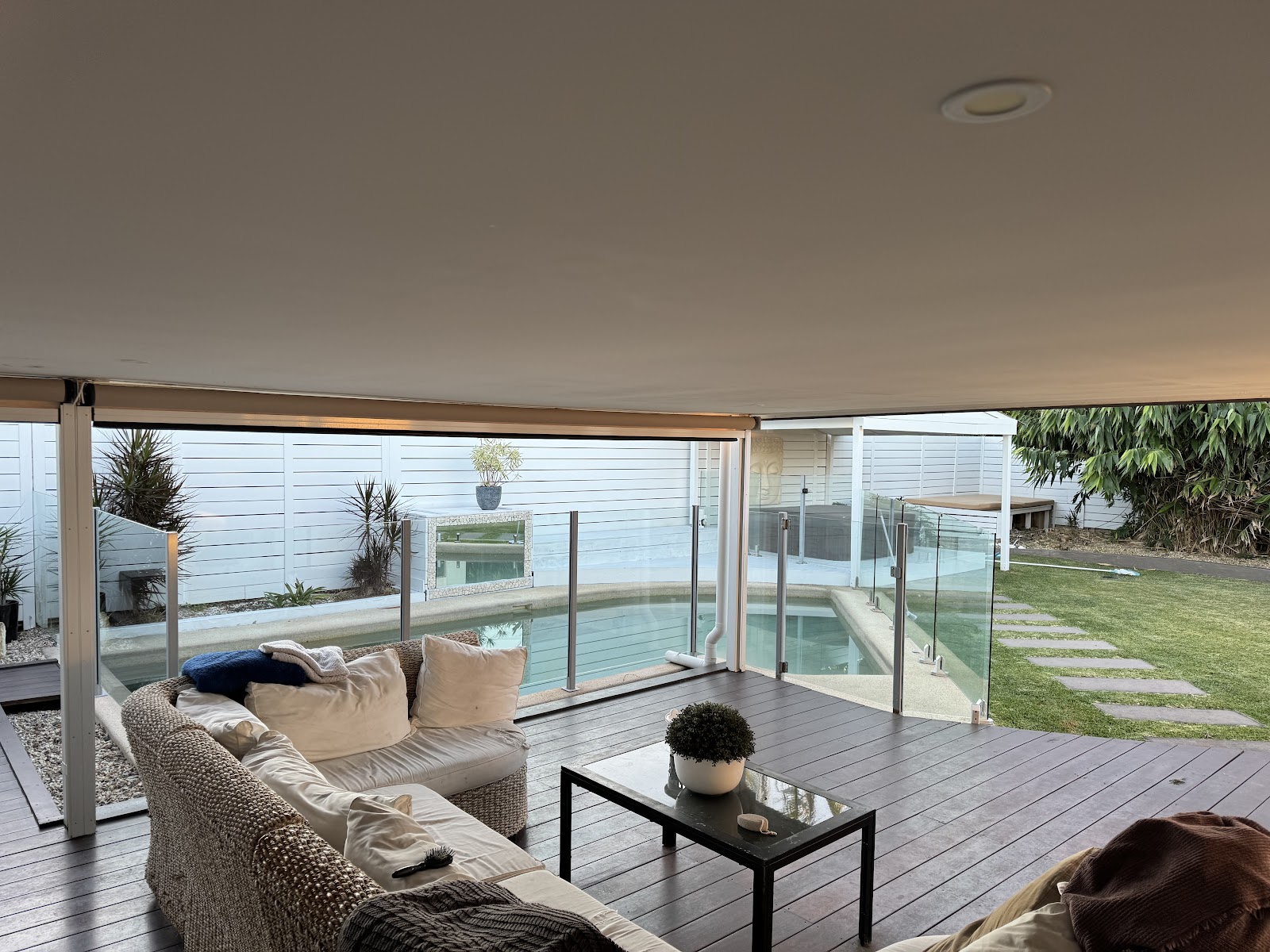 Covered hardwood deck with outdoor lounge looking over a pool