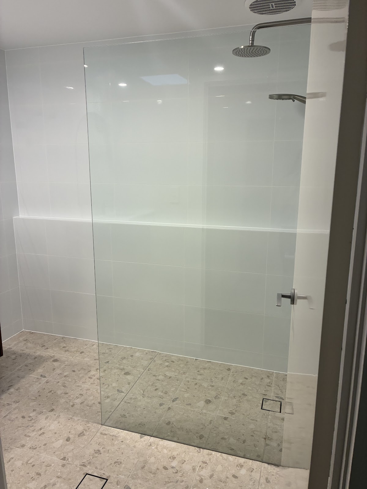 Walk-in shower with frameless glass and a rain shower head